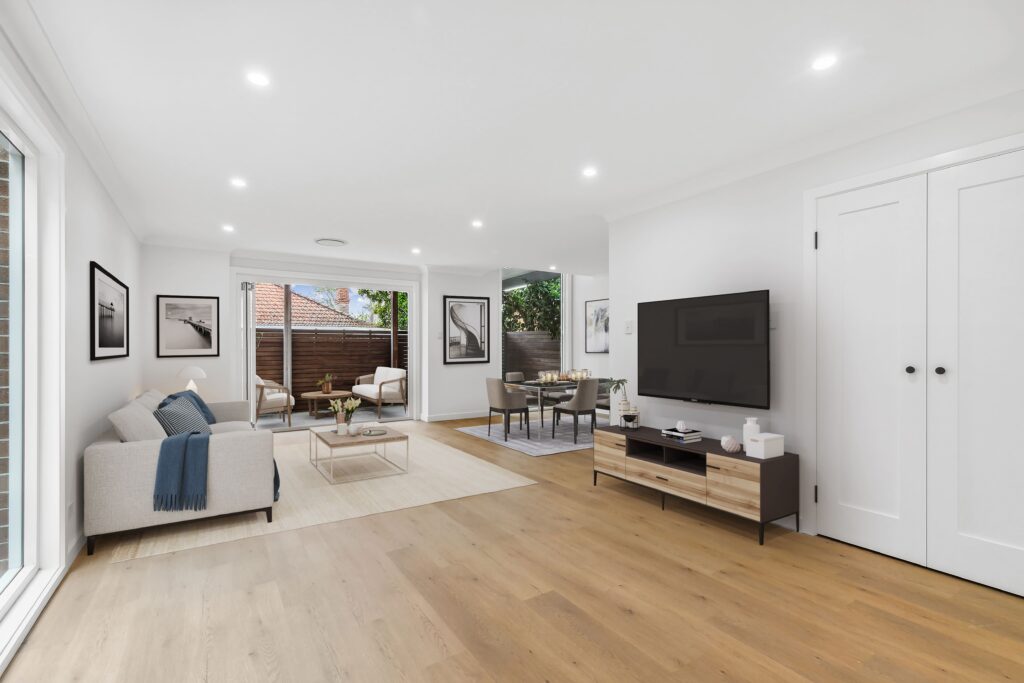 Living and dining area with timber flooring, a wall-mounted television and glazed doors