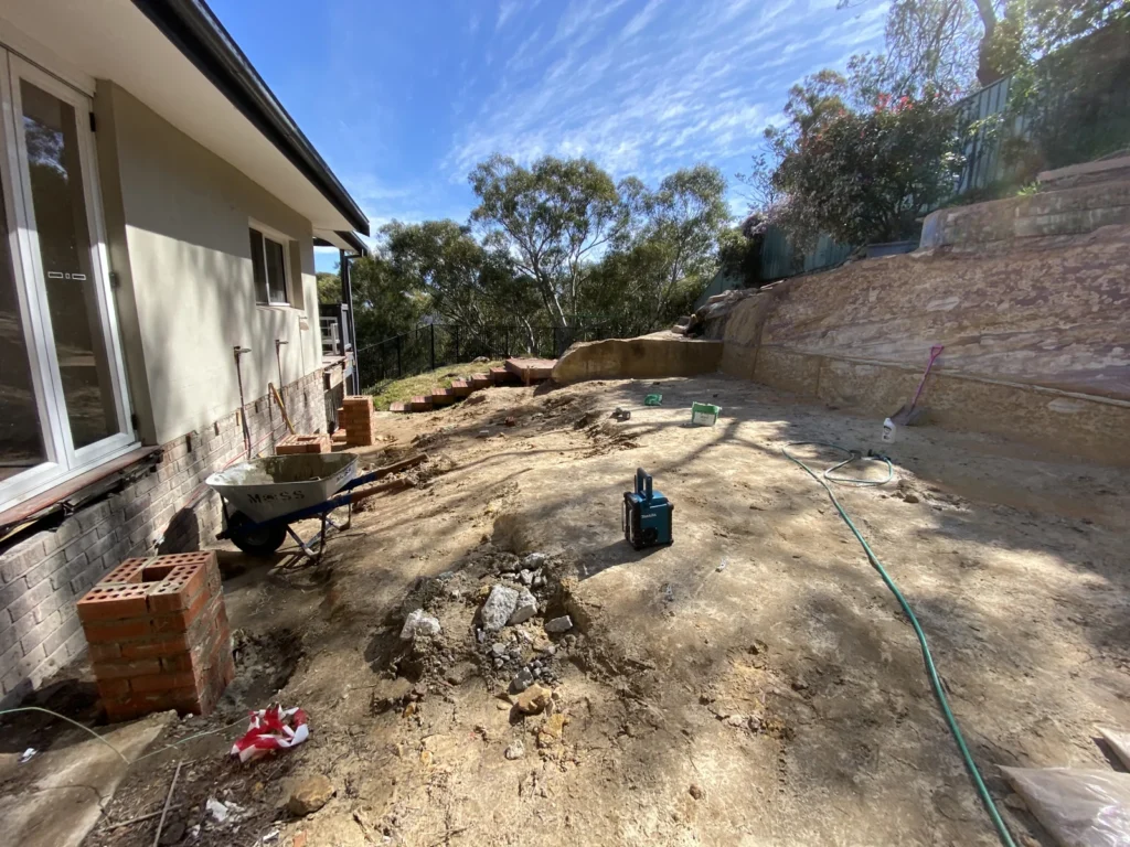 Brick piers beside the existing house and excavated sandstone on the sloping extension site