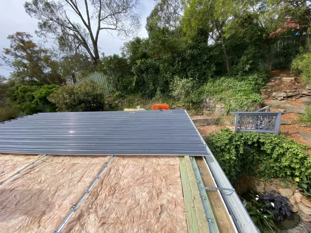 Metal roof sheeting being installed over the roof substrate