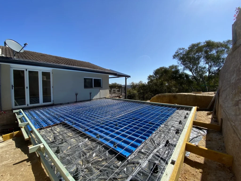 Reinforcement and slab formwork beside the existing home